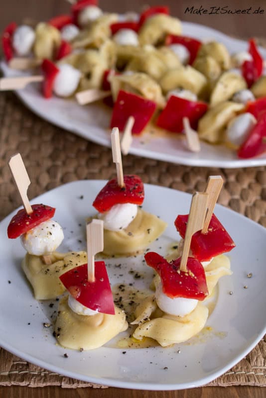 Tortellini Spieße mit Paprika und Mozzarella 1 Tortellini Spieße mit Paprika und Mozzarella auf Tellern