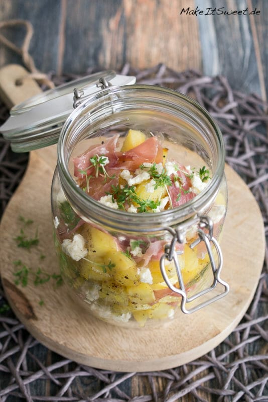 Ofenkartoffel-Schinken-Salat im Glas 1 Ofenkartoffel-Schinken-Salat in einem Glas mit Feta und Kresse auf einem Brett