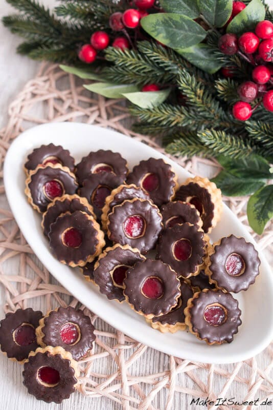 Blankenhagener Plätzchen auf einem Teller: Zusammengesetzte Kreise, bestrichen mit Schokolade, mit einem Loch, das mit Marmelade gefüllt ist.