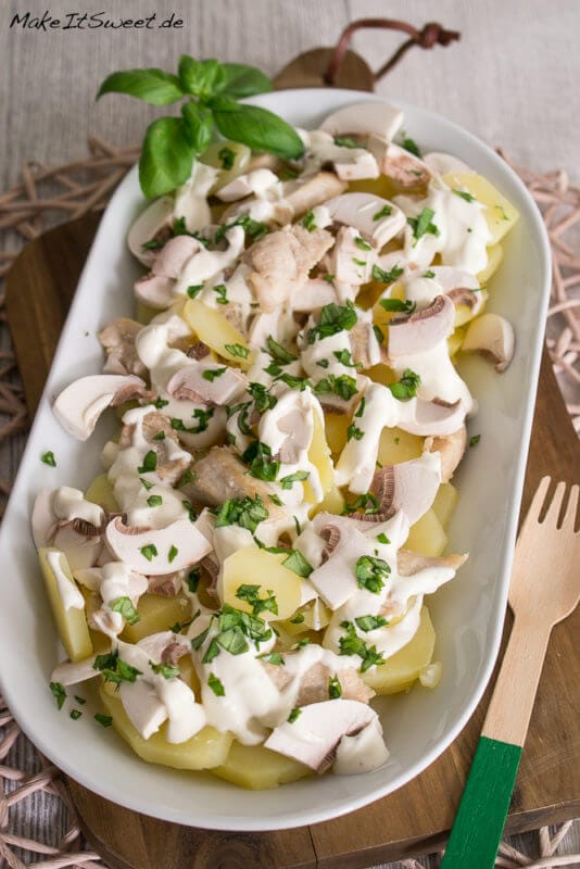 Kartoffelsalat mit Champignons und Schmandsoße in einer länglichen Schüssel